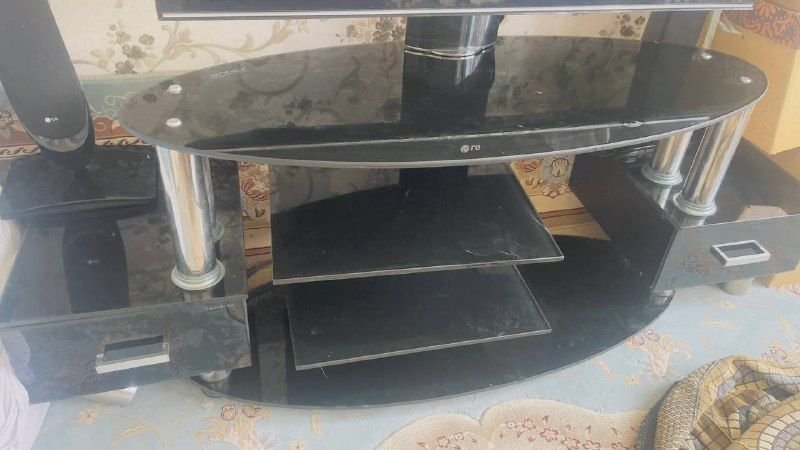 There is a TV table made of glass, black color, Nuno, and it is in good condition. The price is 3000. Please contact Joramed on 0799294595.